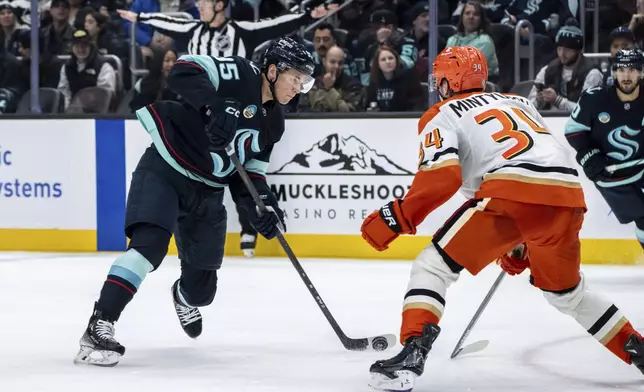 Seattle Kraken forward Andre Burakovsky takes a shot against Anaheim Ducks defenseman Pavel Mintyukov during the second period of an NHL hockey game, Wednesday, Nov. 27, 2024, in Seattle. (AP Photo/Stephen Brashear)