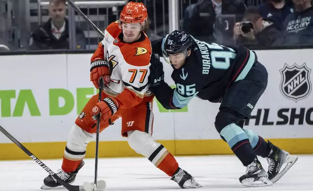 Anaheim Ducks forward Frank Vatrano (77) and forward Andre Burakovsky battle for puck during the second period of an NHL hockey game, Wednesday, Nov. 27, 2024, in Seattle. (AP Photo/Stephen Brashear)