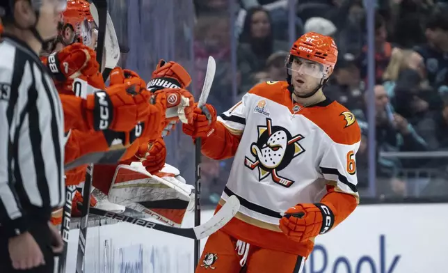 Anaheim Ducks forward Cutter Gauthier is congratulated by teammates on the bench after scoring a goal during the second period of an NHL hockey game against the Seattle Kraken, Wednesday, Nov. 27, 2024, in Seattle. (AP Photo/Stephen Brashear)