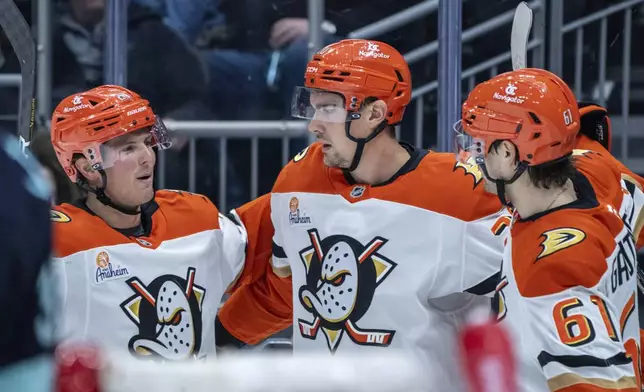 Anaheim Ducks forward Brett Leason, center, is congratulated by forward Isac Lundestrom, left, and forward Cutter Gauthier after scoring a goal during the first period of an NHL hockey game Seattle Kraken, Wednesday, Nov. 27, 2024, in Seattle. (AP Photo/Stephen Brashear)