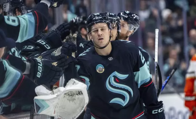 Seattle Kraken forward Eeli Tolvanen is congratulated by teammates on the bench after scoring a goal during the first period of an NHL hockey game against the Anaheim Ducks, Wednesday, Nov. 27, 2024, in Seattle. (AP Photo/Stephen Brashear)