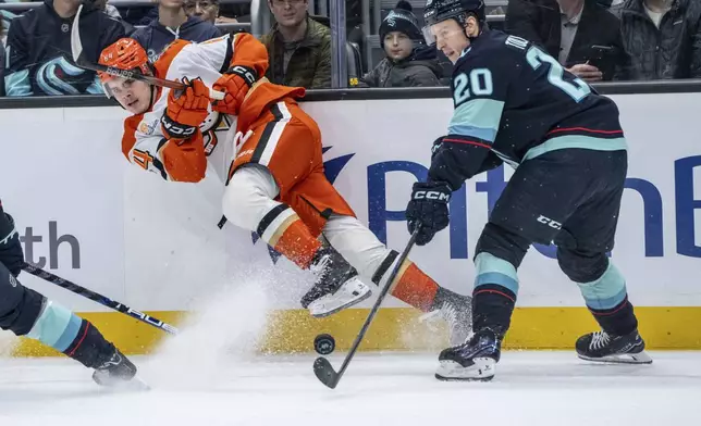 Anaheim Ducks forward Sam Colangelo, left, passes the puck against Seattle Kraken forward Eeli Tolvanen during the first period of an NHL hockey game, Wednesday, Nov. 27, 2024, in Seattle. (AP Photo/Stephen Brashear)