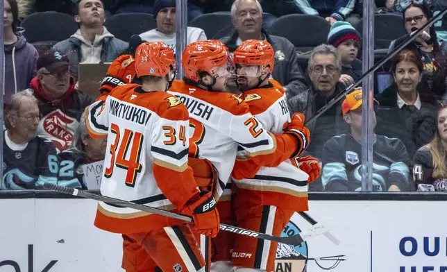 Anaheim Ducks, from left, defenseman Pavel Mintyukov, forward Mason McTavish and forward Alex Killorn celebrate a gold during the second period of an NHL hockey game against the Seattle Kraken, Wednesday, Nov. 27, 2024, in Seattle. (AP Photo/Stephen Brashear)