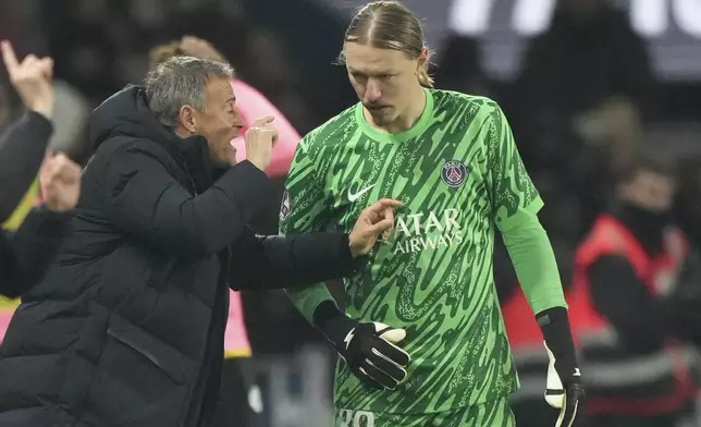 PSG's head coach Luis Enrique talks to goalkeeper Matvey Safonov during the French League One soccer match between Paris Saint-Germain and Toulouse at the Parc des Princes stadium in Paris, France, Sunday, Nov. 22, 2024. (AP Photo/Michel Euler)
