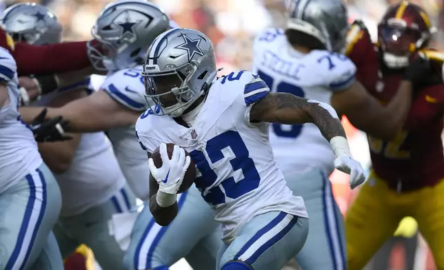 Dallas Cowboys running back Rico Dowdle (23) runs with the football during the first half of an NFL football game against the Washington Commanders, Sunday, Nov. 24, 2024, in Landover, Md. (AP Photo/Nick Wass)