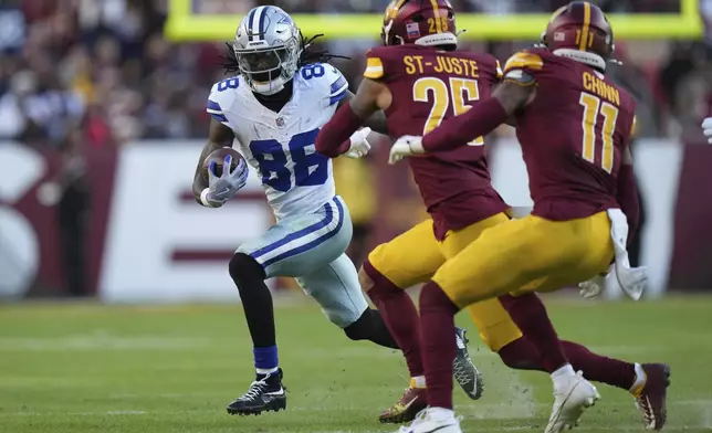 Dallas Cowboys wide receiver CeeDee Lamb (88) runs with the football as Washington Commanders cornerback Benjamin St-Juste (25) and safety Jeremy Chinn (11) try to tackle during the second half of an NFL football game, Sunday, Nov. 24, 2024, in Landover, Md. (AP Photo/Stephanie Scarbrough)