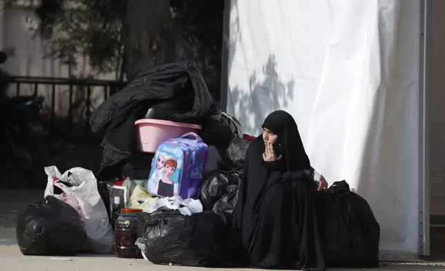 A girl waits at the border between Lebanon and Syria as Lebanese families return to Lebanon through the Jousieh border crossing, Syria, Thursday, Nov. 28, 2024, following a ceasefire between Israel and Hezbollah that went into effect on Wednesday. (AP Photo/Omar Sanadiki)