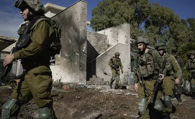 Israeli soldiers inspect the site where a rocket fired from Lebanon landed in a backyard in Kiryat Shmona, northern Israel, Tuesday Nov. 26, 2024. (AP Photo/Leo Correa)