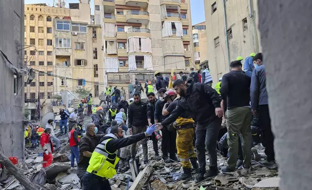 Rescuers search for victims at the site of an Israeli airstrike that targeted a building in Beirut, Lebanon, Tuesday, Nov. 26, 2024. (AP Photo/Hassan Ammar)