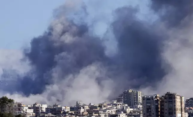 Smoke rises between buildings hit in Israeli airstrikes in Hosh neighbourhood, in Tyre, south Lebanon, Tuesday, Nov. 26, 2024. (AP Photo/Hussein Malla)