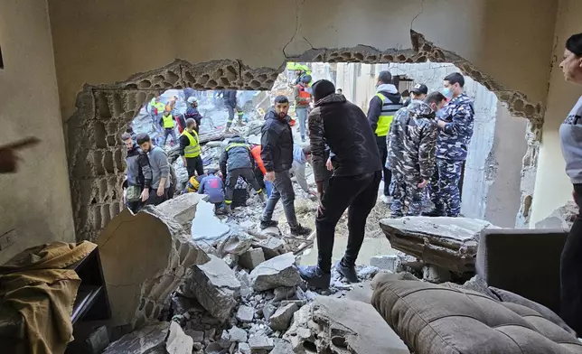 Rescuers and residents search for victims at the site of an Israeli airstrike that targeted a building in Beirut, Lebanon, Tuesday, Nov. 26, 2024. (AP Photo/Hassan Ammar)