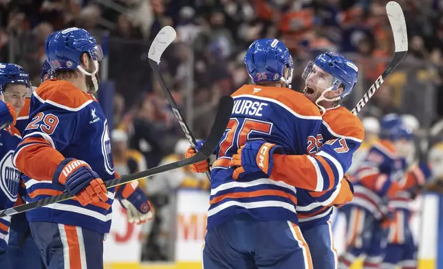 Edmonton Oilers' Darnell Nurse (25) and Connor McDavid (97) celebrate after their win over the Nashville Predators during overtime NHL hockey game action in Edmonton, Alberta, Thursday, Nov. 14, 2024. (Jason Franson/The Canadian Press via AP)