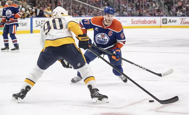 Nashville Predators' Ryan O'Reilly (90) and Edmonton Oilers' Connor McDavid (97) battle for the puck during the second period of an NHL hockey game, Thursday, Nov. 14, 2024 in Edmonton, Alberta. (Jason Franson/The Canadian Press via AP)