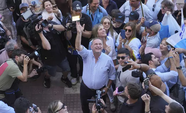 Alvaro Delgado, candidate for the ruling National Party, waves after voting in the presidential run-off election in Montevideo, Uruguay, Sunday, Nov. 24, 2024. (AP Photo/Natacha Pisarenko)