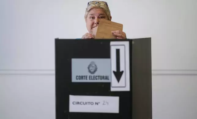 Yeni Varone, a nurse, casts her vote in the presidential run-off election in Montevideo, Uruguay, Sunday, Nov. 24, 2024. (AP Photo/Natacha Pisarenko)