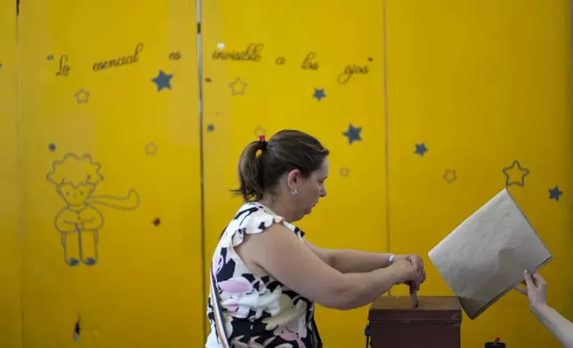 A woman votes in the presidential run-off election in Canelones, Uruguay, Sunday, Nov. 24, 2024. (AP Photo/Matilde Campodonico)