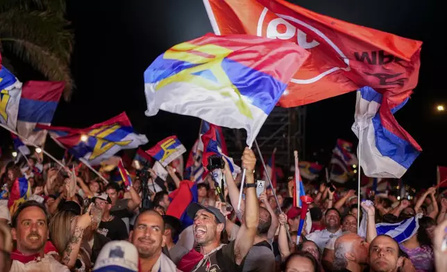 Supporters of Yamandu Orsi, candidate for the Broad Front (Frente Amplio), celebrate early results after polls closed in the presidential run-off election in Montevideo, Uruguay, Sunday, Nov. 24, 2024. (AP Photo/Natacha Pisarenko)