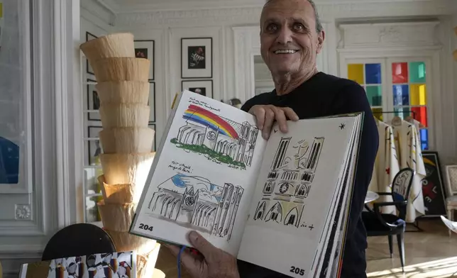 Designer Jean-Charles de Castelbajac displays his book with drawings of the Notre-Dame Cathedral during an interview with the Associated Press, Wednesday, Nov. 20, 2024 in Paris. (AP Photo/Michel Euler)