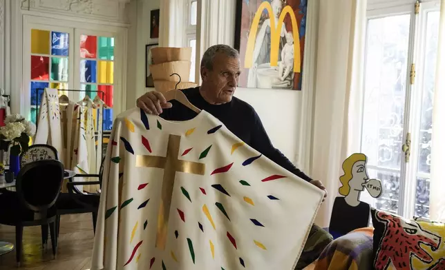 Designer Jean-Charles de Castelbajac displays a liturgical vestment for priests and to be worn at the reopening of Paris' Notre-Dame Cathedral in December, Wednesday, Nov. 20, 2024 in Paris. (AP Photo/Michel Euler)