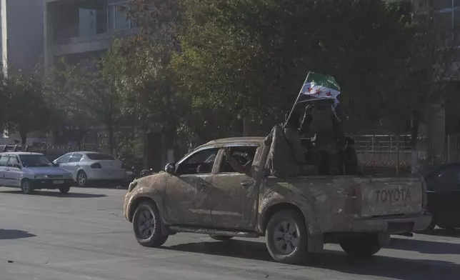 Opposition fighters ride along the streets of Aleppo, Syria, Saturday Nov. 30, 2024. (AP Photo/Ghaith Alsayed)