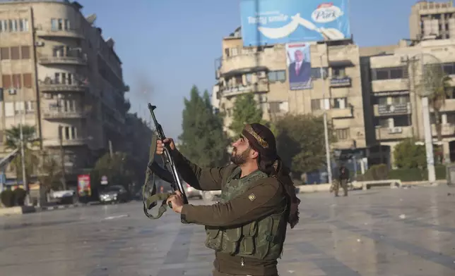 A Syrian opposition fighter shoots in the air in downtown Aleppo, Syria, Saturday Nov. 30, 2024. (AP Photo/Ghaith Alsayed)