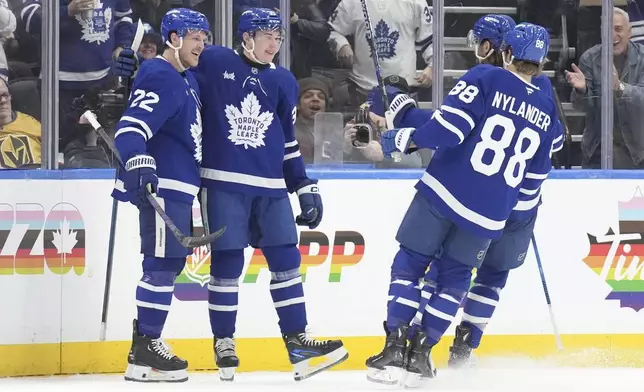 Toronto Maple Leafs' Fraser Minten (39) celebrates with Jake McCabe (22) and William Nylander (88) after scoring the team's opening goal against Vegas Golden Knights during first period NHL hockey action in Toronto, on Wednesday, November 20, 2024. (Chris Young/The Canadian Press via AP)