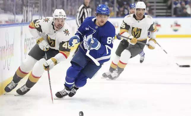 Toronto Maple Leafs' William Nylander (88) and Vegas Golden Knights' Tomas Hertl (48) chase down the puck during second period NHL hockey action in Toronto, on Wednesday, November 20, 2024. (Chris Young/The Canadian Press via AP)