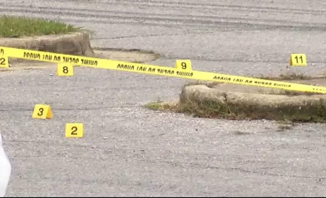 This image taken from video provided by WSFA shows evidence markers as law enforcement work at the scene of a shooting at Tuskegee University, Sunday, Nov. 10, 2024, in Tuskegee, Ala. (WSFA via AP)