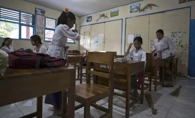 Ketut Nita Wahyuni, second right, sits in her classroom in Geriana Kauh village, Karangasem, Bali, Indonesia on Thursday, Nov. 21, 2024. (AP Photo/Firdia Lisnawati)