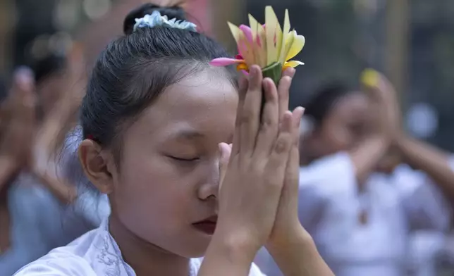 Ketut Nita Wahyuni, 11, prays as she perform a Hindu ritual at Geriana Kauh village, Karangasem, Bali, Indonesia, Wednesday, Nov. 20, 2024. (AP Photo/Firdia Lisnawati)