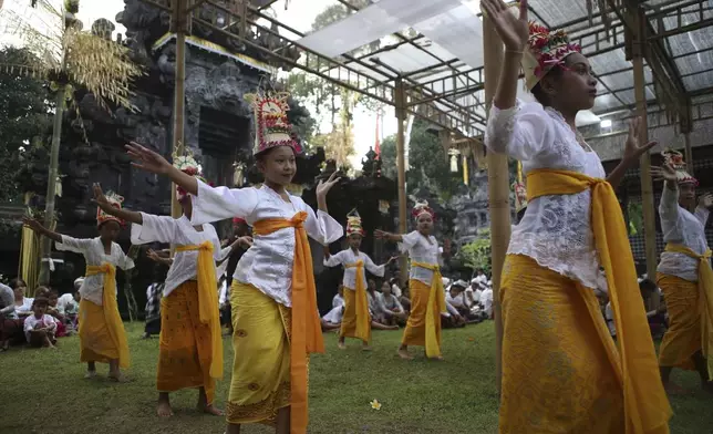 Ketut Nita Wahyuni, 11, centre, performs the Rehang Dewa, a sacred Balinese dance, at Geriana Kauh village, Karangasem, Bali, Indonesia on Wednesday, Nov. 20, 2024. (AP Photo/Firdia Lisnawati)