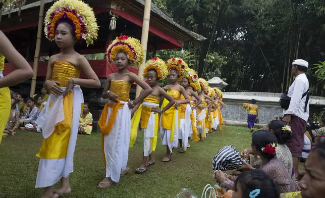 Ketut Nita Wahyuni, left, participates in Rejang Pucuk at Geriana Kauh village, Karangasem, Bali, Indonesia, Thursday, Nov. 21, 2024. (AP Photo/Firdia Lisnawati)