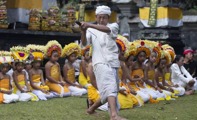 A Hindu priest in trance points keris, traditional dagger, on his chest during a Hindu ceremony at Geriana Kauh village, Karangasem, Bali, Indonesia, Thursday, Nov. 21, 2024. (AP Photo/Firdia Lisnawati)