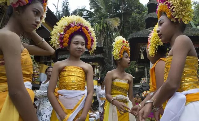 Ketut Nita Wahyuni, second left, stands with her friends as they participate in Rejang Pucuk in at Geriana Kauh village, Karangasem, Bali, Indonesia, Thursday, Nov. 21, 2024. (AP Photo/Firdia Lisnawati)