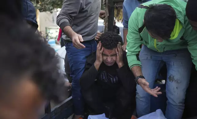 Palestinians mourn their relatives killed in the Israeli bombardment of Maghazi in the Gaza Strip, during their funeral at a hospital morgue in Deir al-Balah, Gaza, Thursday, Nov. 14, 2024. (AP Photo/Abdel Kareem Hana)