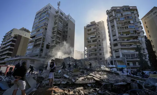 Residents check the site of an Israeli airstrike in Tayouneh, Beirut, Lebanon, Friday, Nov. 15, 2024. (AP Photo/Hassan Ammar)