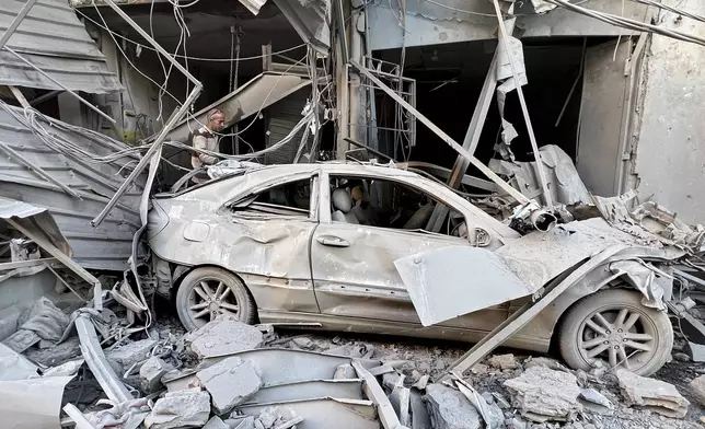 A man checks his destroyed shop at a street that was hit in an Israeli airstrike in Dahiyeh, in the southern suburb of Beirut, Lebanon, Thursday, Nov. 14, 2024. (AP Photo/Hussein Malla)