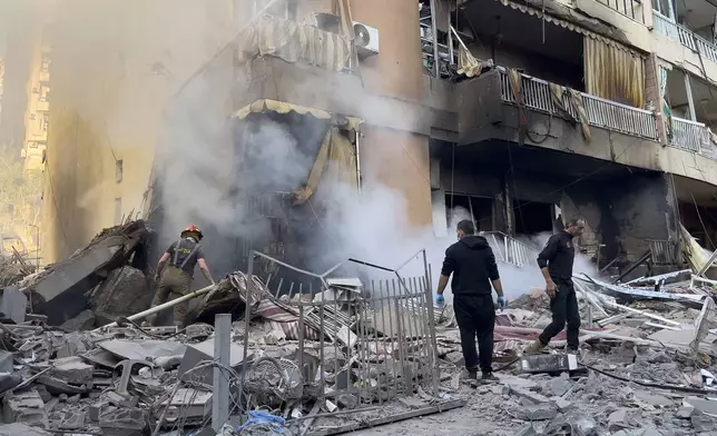 Firefighters check a destroyed building that was hit in an Israeli airstrike in Dahiyeh, in the southern suburb of Beirut, Lebanon, Thursday, Nov. 14, 2024. (AP Photo/Hussein Malla)