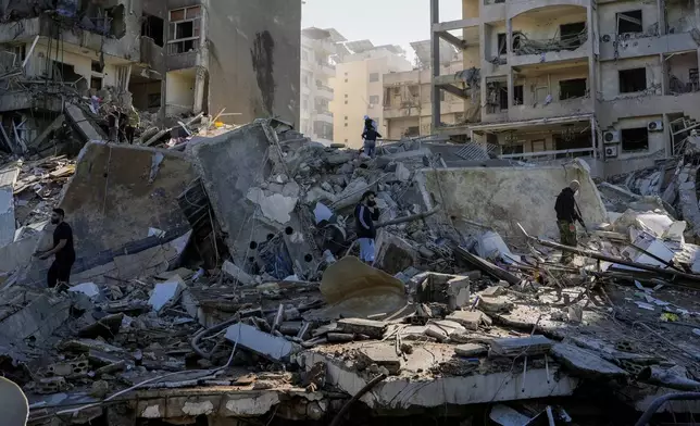 Residents check the site of an Israeli airstrike in Tayouneh, Beirut, Lebanon, Friday, Nov. 15, 2024. (AP Photo/Hassan Ammar)