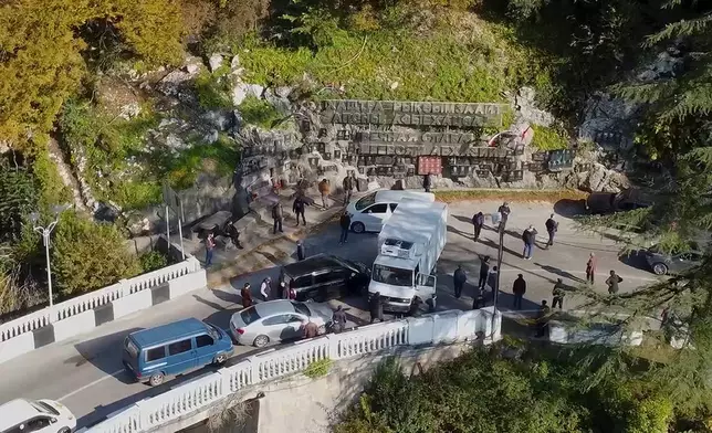 In this photo taken from video released by the Information Center of the President of the Republic of Abkhazia on Tuesday, Nov. 12, 2024, protesters block the way to the bridge over the Gumista River, about 5,5 kilometres south of Sukhumi in the Georgian separatist region of Abkhazia, Georgia. (Information Center of the President of the Republic of Abkhazia via AP)