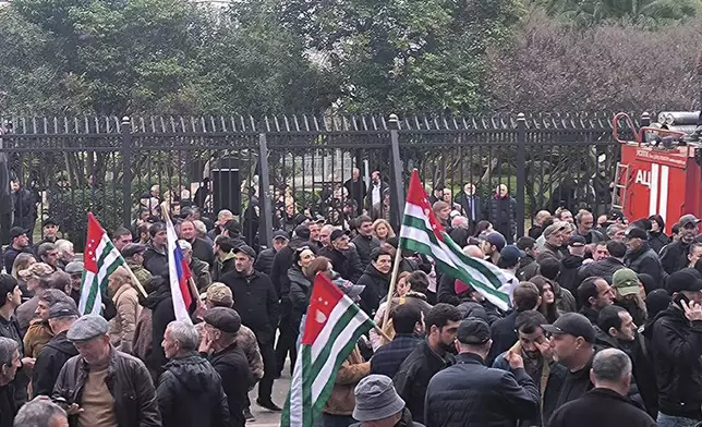 In this photo taken from video released by AIASHARA Independent Agency, Protesters with Abkhazian flags gather outside the parliament building of the Georgian separatist region of Abkhazia as tensions flared over a proposed pact that would allow Russians to buy apartments in the region, Georgia, on Friday, Nov. 15, 2024, (AIASHARA Independent Agency via AP)