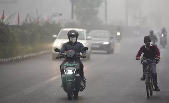 Commuters drive through a thick layer of smog as air pollution shoots up in New Delhi, India, Monday, Nov. 18, 2024. (AP Photo/Manish Swarup)