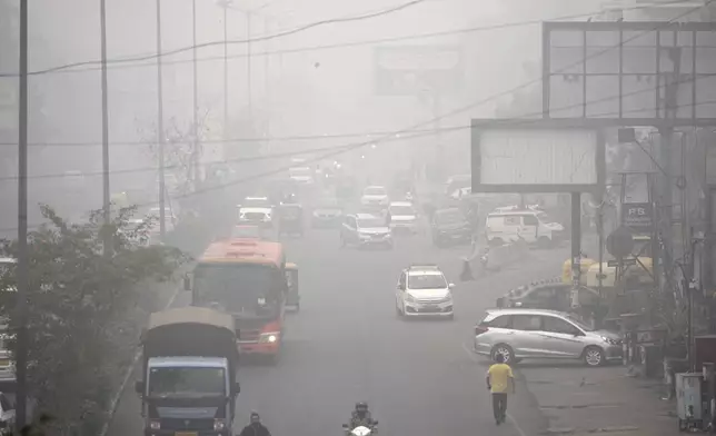 Commuters drive through a thick layer of smog as air pollution shoots up in New Delhi, India, Monday, Nov. 18, 2024. (AP Photo/Manish Swarup)