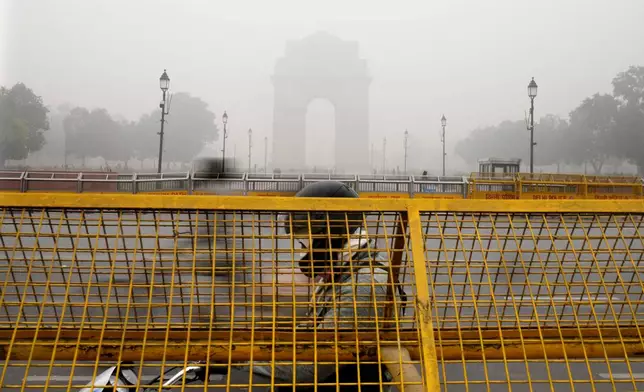 A commuter drives amidst a thick layer of smog as air pollution shoots up in New Delhi, India, Monday, Nov. 18, 2024. (AP Photo/Manish Swarup)