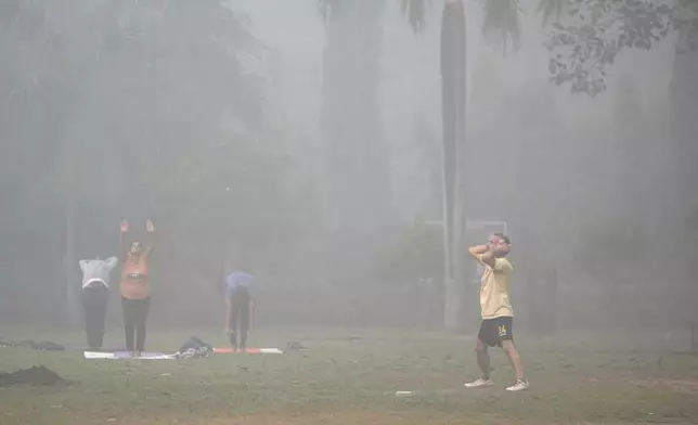 Bashir Ahmad Mir performs morning exercises surrounded by smog in Lodhi Gardens in New Delhi, India, Friday, Nov. 15, 2024. (AP Photo/Manish Swarup)