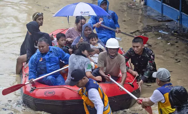 Rescuers use rubber boat to help residents evacuate their homes in a flooded neighborhood following heavy downpours in Medan, North Sumatra, Indonesia, Wednesday, Nov. 27, 2024. (AP Photo/Binsar Bakkara)