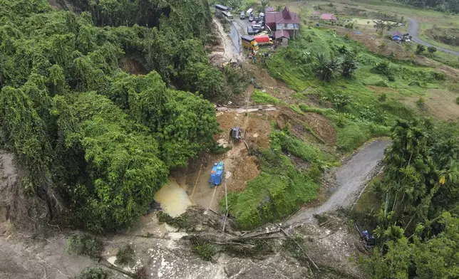 Wreckage of vehicles rest on a road that was hit by a landslide that killed multiple people in Deli Serdang, North Sumatra, Indonesia, Thursday, Nov. 28, 2024. (AP Photo/Binsar Bakkara)