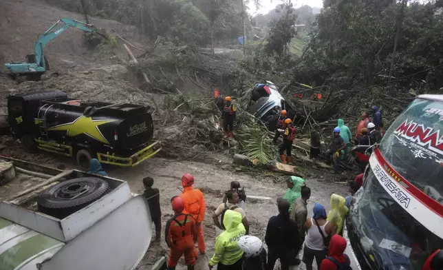 Rescuers use heavy machine to clear mud from a road following a landslide that hit several vehicles and killed multiple people in Deli Serdang, North Sumatra, Indonesia, Thursday, Nov. 28, 2024. (AP Photo/Binsar Bakkara)