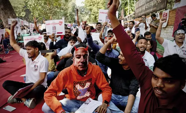 A participant wears a paper mask in the likeness of Amazon's Jeff Bezos as warehouse workers and delivery drivers stage a protest against the Seattle-based company demanding higher wages and better working conditions, in New Delhi, India, Friday, Nov. 29, 2024. (AP Photo/Manish Swarup)