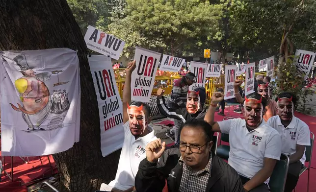 Participants wear paper masks in the likeness of Amazon's Jeff Bezos as warehouse workers and delivery drivers stage a protest against the Seattle-based company demanding higher wages and better working conditions, in New Delhi, India, Friday, Nov. 29, 2024. (AP Photo/Manish Swarup)